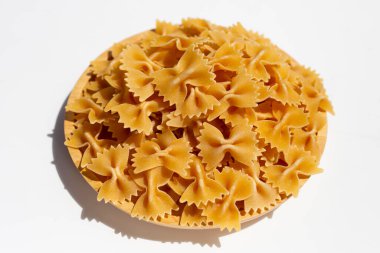 Beyaz arka plan üzerinde pişmemiş fiyonk makarna.