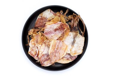 Beyaz arka planda siyah tabakta kurutulmuş mürekkep balığı..