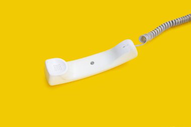 Sarı arka planda sabit telefon ahizesi.