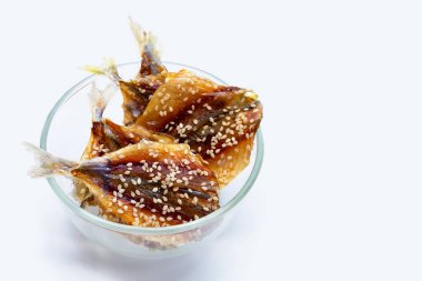 Beyaz arka planda susam tohumlu kurutulmuş balık..