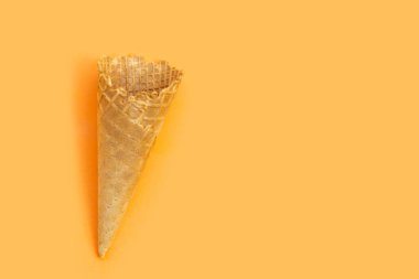 Turuncu arka planda boş dondurma külahı.