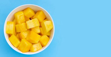 Mavi arkaplanda sarı mango küp dilimleri.