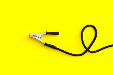 Welding ground clamp on yellow background.