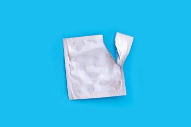 Mavi arkaplanda boş prezervatif paketleri