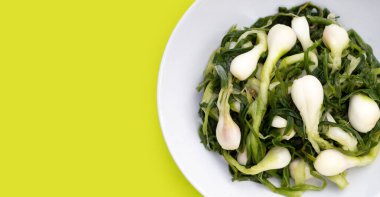 Beyaz tabakta turşulu taze soğan.