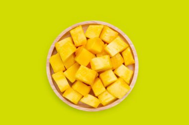 Yeşil zemin üzerinde sarı mango küp dilimleri.