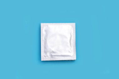 Mavi arka planda prezervatif. Boşluğu kopyala