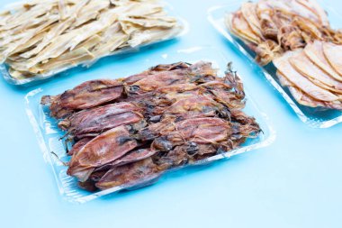 Mavi arkaplanda kurumuş mürekkep balığı.