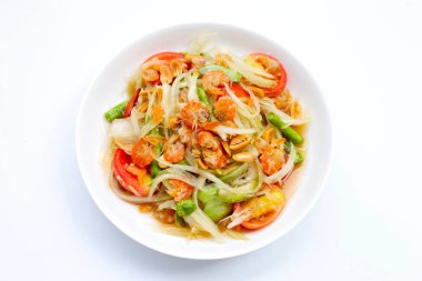 Beyaz arka planda baharatlı papaya salatası tabağı.