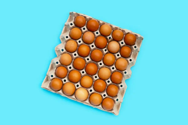 Mavi Arka Planda Kağıt Yumurta Sandığındaki Tavuk Yumurtaları — Stok fotoğraf