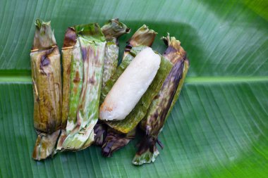 Grilled sticky rice in banana leaves with banana filling