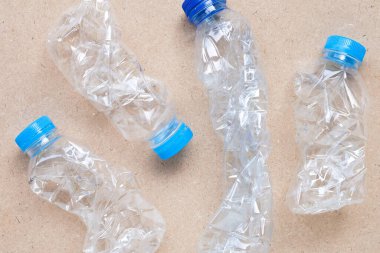 Kahverengi arka planda plastik süt şişeleri.