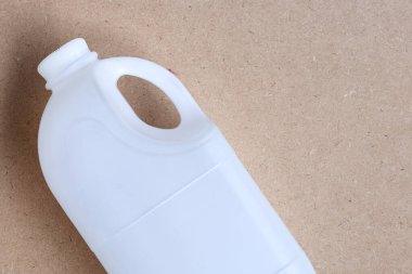Kahverengi arka planda plastik süt şişesi. 