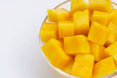 Beyaz arkaplanda sarı mango dilimleri.