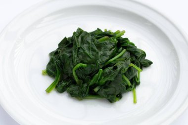 Beyaz arkaplanda haşlanmış ıspanak.