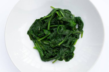 Beyaz arkaplanda haşlanmış ıspanak.