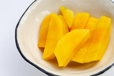 Beyaz kasede sarı mango dilimleri