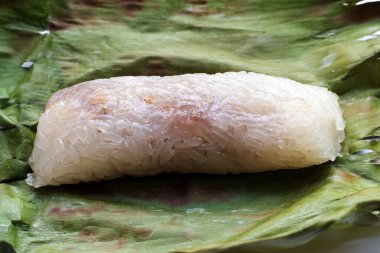Grilled sticky rice in banana leaves with banana filling