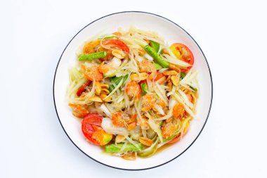 Beyaz arka planda baharatlı papaya salatası tabağı.