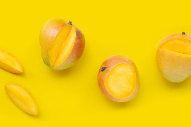 Tropik meyve, sarı arka planda mango. Üst görünüm