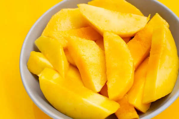 Tropical fruit, Mango slices on yellow background
