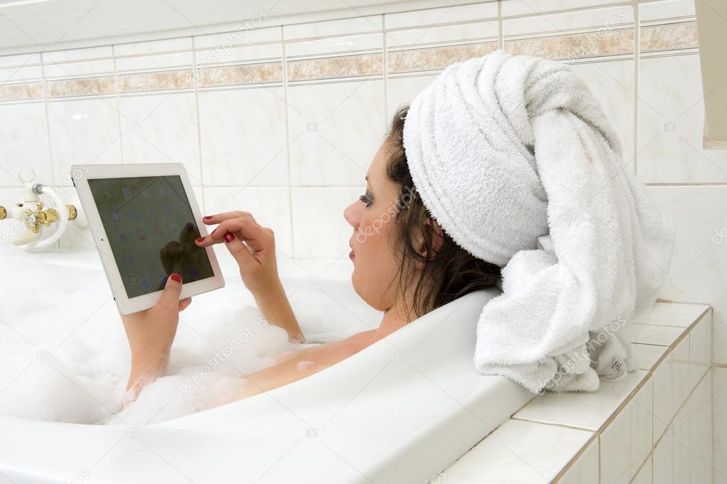 With iPad in bath