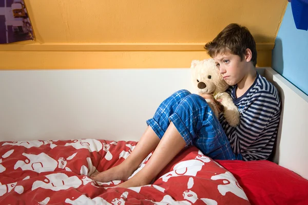 Niño triste y deprimido en su cama — Foto de Stock