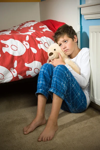 Грустный и подавленный мальчик в своей спальне — стоковое фото