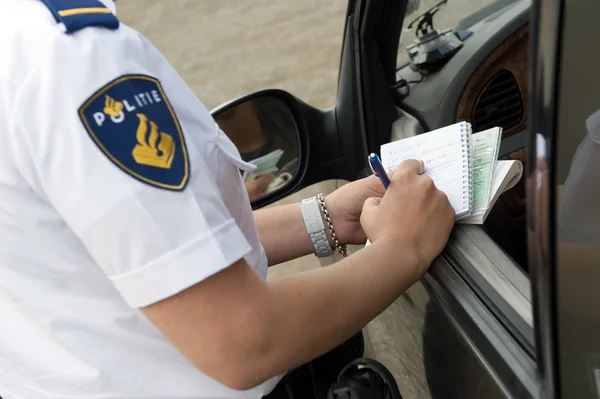 Polizistin schreibt auf Notizbuch — Stockfoto