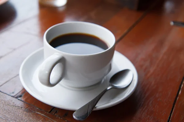 Café preto em uma xícara branca na mesa . — Fotografia de Stock