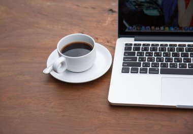 bir tablo ile bir bilgisayar üzerinde beyaz bir fincan sade kahve.