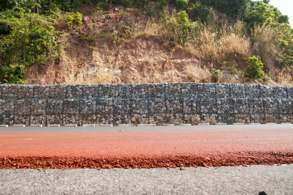 Stenen blok ter voorkoming van aardverschuivingen langs de weg. — Stockfoto