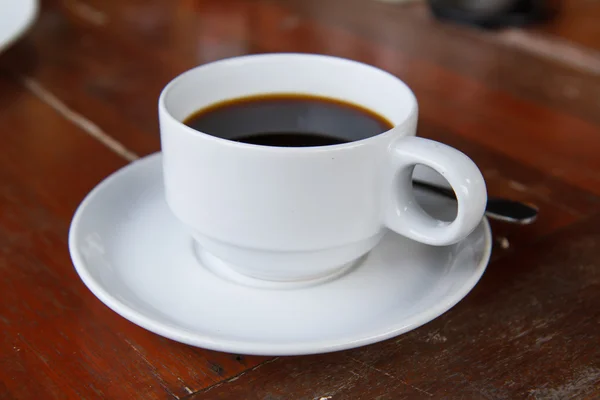 Μαύρο καφέ σε ένα λευκό φλιτζάνι στο τραπέζι. — Φωτογραφία Αρχείου