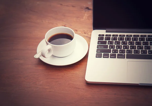 bir tablo ile bir bilgisayar üzerinde beyaz bir fincan sade kahve.