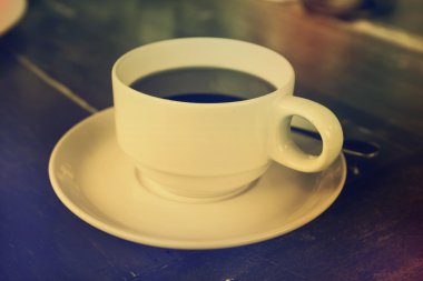 Masanın üzerinde beyaz bir fincan sade kahve.