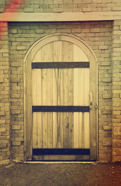 Vieja puerta de madera en la pared de ladrillo — Foto de Stock