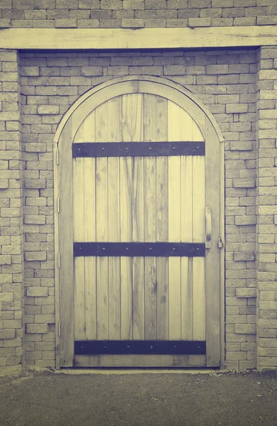 Старая деревянная дверь в кирпичной стене — стоковое фото
