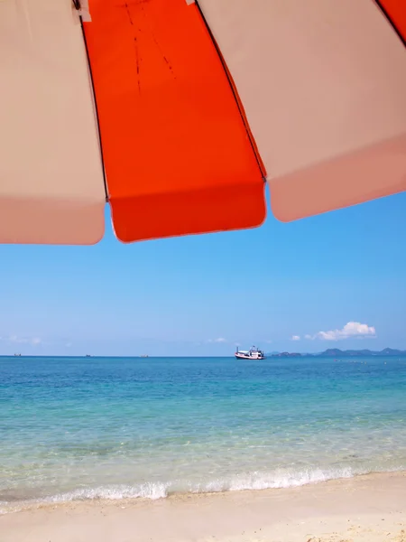 Sunshade on beach with boat — Stock Photo, Image