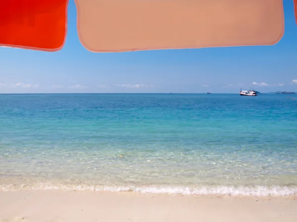 Sunshade on beach with boat — Stock Photo, Image