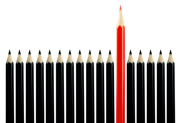 Red pencil among black pencils Royalty Free Stock Photos