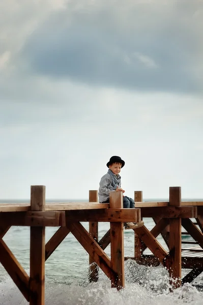 Junge auf der Brücke am Meer — Stockfoto