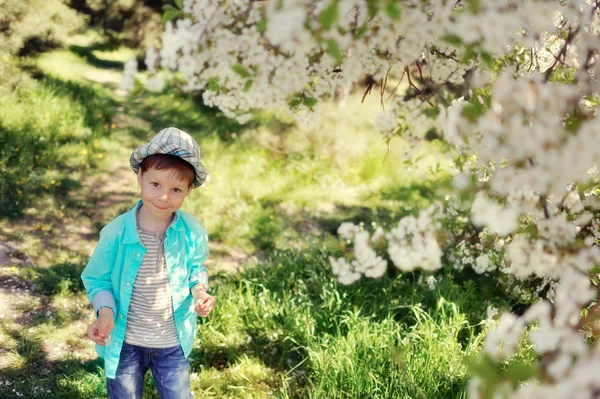 Menino em um jardim exuberante — Fotografia de Stock