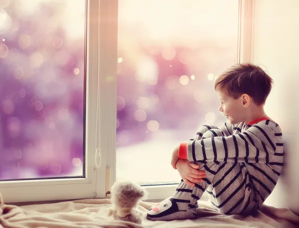 เด็กชายในหน้าต่างฤดูหนาว รูปภาพสต็อกที่ปลอดค่าลิขสิทธิ์