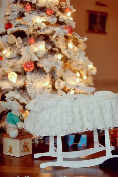 Cot under the Christmas tree — Stock Photo, Image
