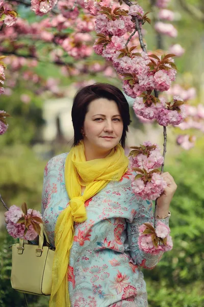 Meisje in de bloemrijke tuin — Stockfoto