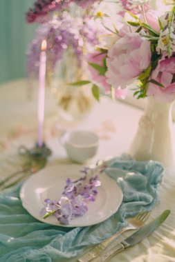 Hassas renkler ve açık tonlarda çiçeklerle süslenmiş şenlik masası