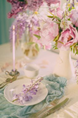 Hassas renkler ve açık tonlarda çiçeklerle süslenmiş şenlik masası