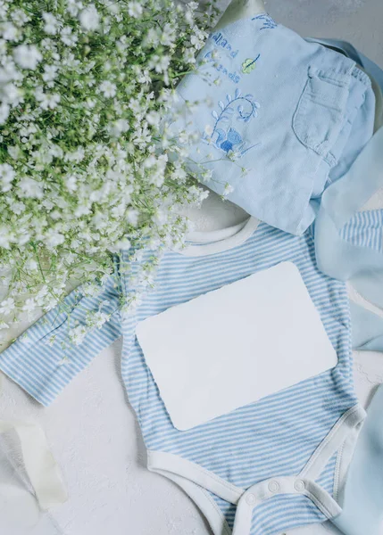 Yeni Doğan Bebek Kıyafetlerinin Arka Planında Mavi Renkli Kartpostallar Var — Stok fotoğraf