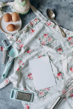 Mutfak masasının üzerinde eski usul mutfak gereçleri olan tarif kitabı maketi.