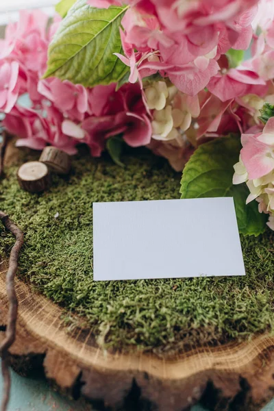 business card mockup in nature style, white paper on green moss and wood cut